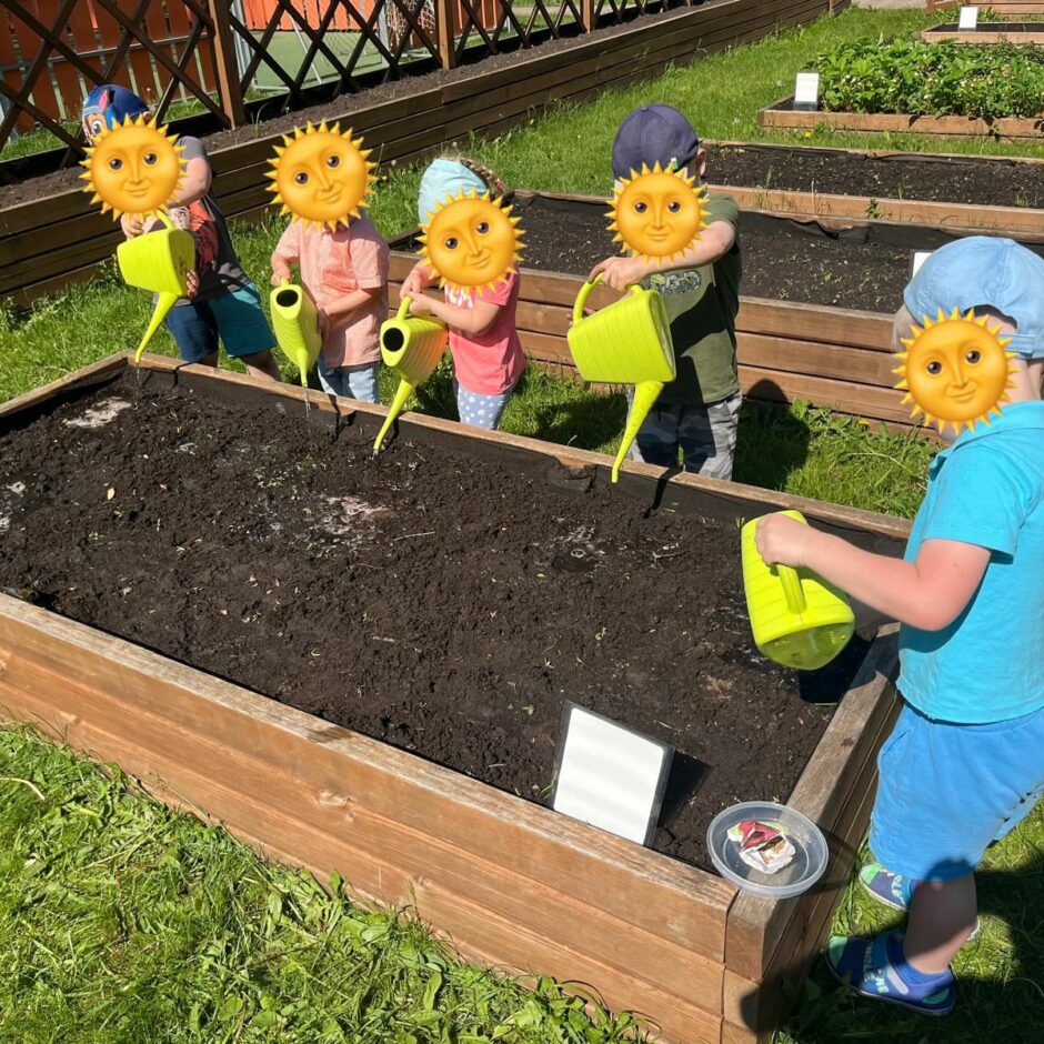 Bērni laista tikko iesētās sēklas dobē