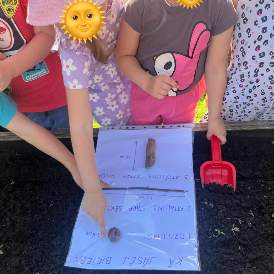 Bērni gatavojās sēt sēklas dobē